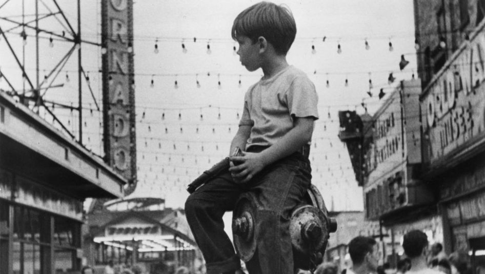 Filmstill aus THE LITTLE FUGITIVE: Ein kleiner Junge sitzt in Coney Island auf einem Hydranten.