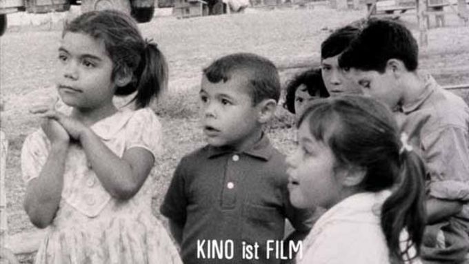 Filmstill aus POR PRIMERA VEZ: Eine Gruppe von Kindern schaut in die Kamera. Unten ist ein Schriftzug mit den Wort Kino ist Film.