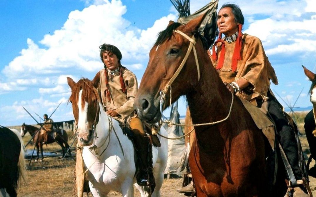 Filmstill aus LITTLE BIG MAN: Zwei Männer in indianischer Kleidung sitzen auf Pferden.