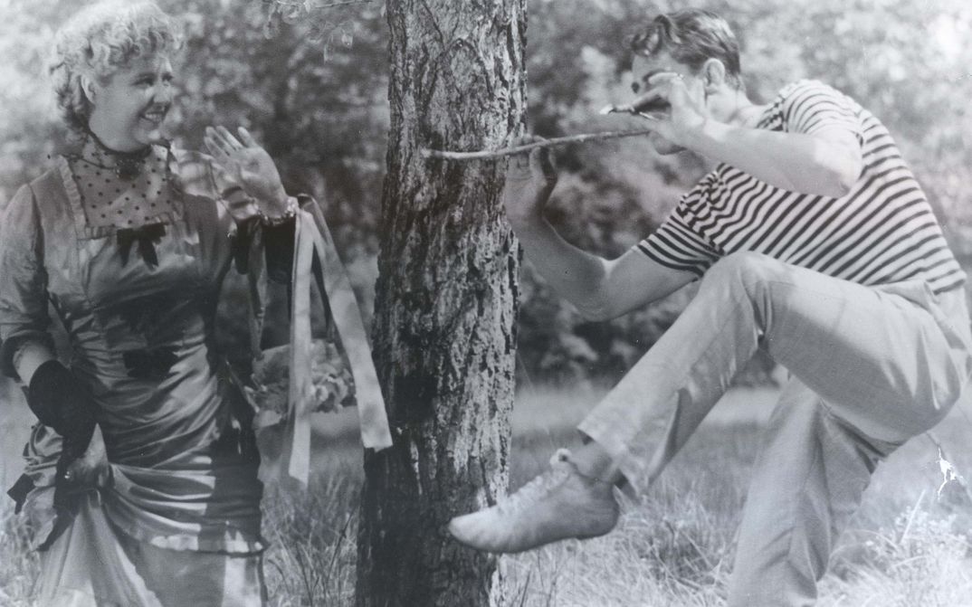 Filmstill aus PARTIE DE CAMPAGNE: Ein Mann und eine Frau in ausgelassener Stimmung in einem Park. 