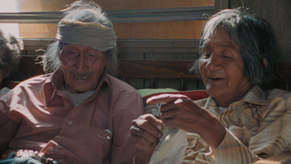 Filmstill aus Techqua Ikachi – Land, mein Leben: Zu sehen sind ein alter Mann und eine alte Frau, die nebeneinander sitzen. 