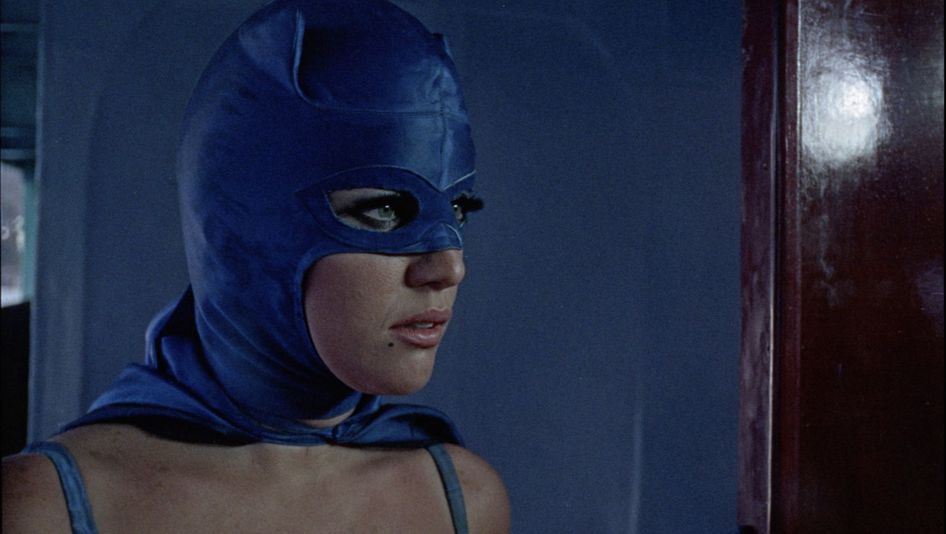 Filmstill aus LA MUJER MURCIÉLAGO: Großaufnahme einer Frau im lila Superheldinnen-Kostüm.