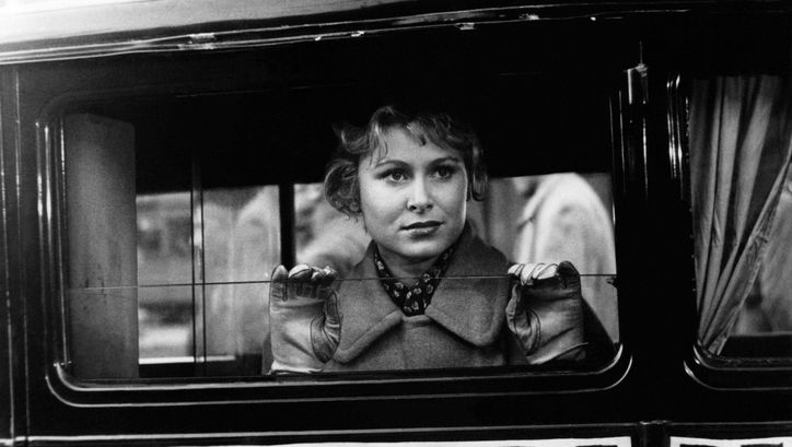 Film still from LISSY: A young woman looks out of a car or bus and holds her hands against the lowered window.
