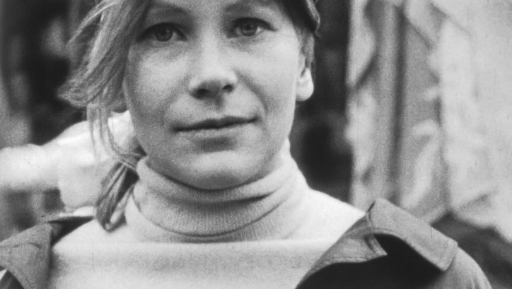 Filmstill aus SUBJEKTITÜDE. Großaufnahme einer jungen Frau, die frontal in die Kamera blickt.