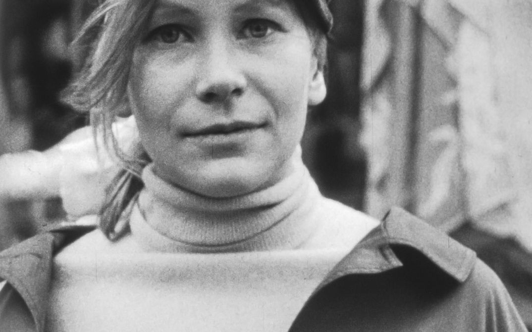 Filmstill aus SUBJEKTITÜDE. Großaufnahme einer jungen Frau, die frontal in die Kamera blickt.