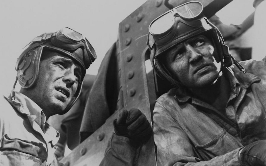 Filmstill aus SAHARA: Zwei Piloten in und neben einem kleinen Flugzeug.