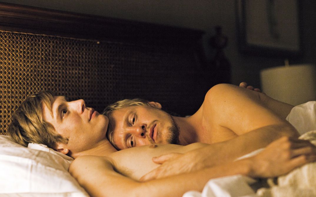 Filmstill aus KEEP THE LIGHTS ON: Zwei junge Männer liegen sich umarmend in einem Bett.