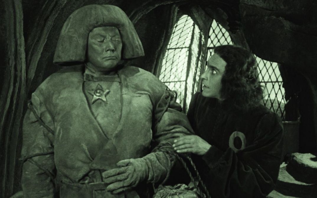 Film still from DER GOLEM, WIE ER IN DIE WELT KAM: A man looks in horror at the clay figure of the golem.