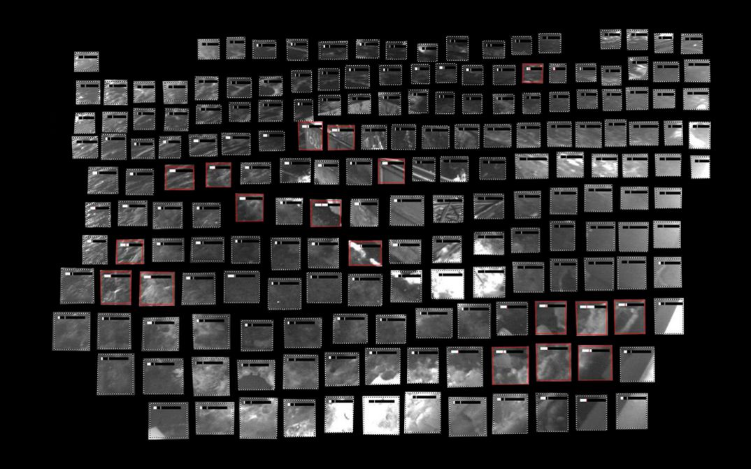 Film still from Utkarsh’s film “Remote Occlusions”. A grid of gray rectangles against a black background, which when put together form an indistinct image from a surveillance camera. Some of the rectangles are outlined in red.
