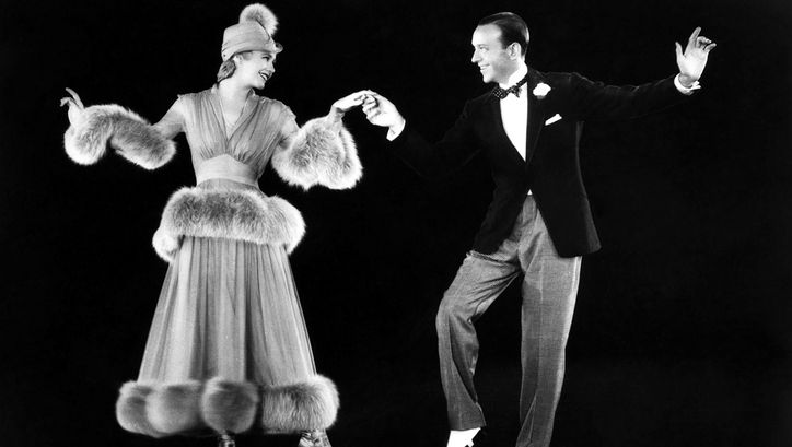 Filmstill aus THE STORY OF VERNON AND IRENE CASTLE. Ginger Rogers und Fred Astaire tanzen vor einem schwarzen Hintergrund.