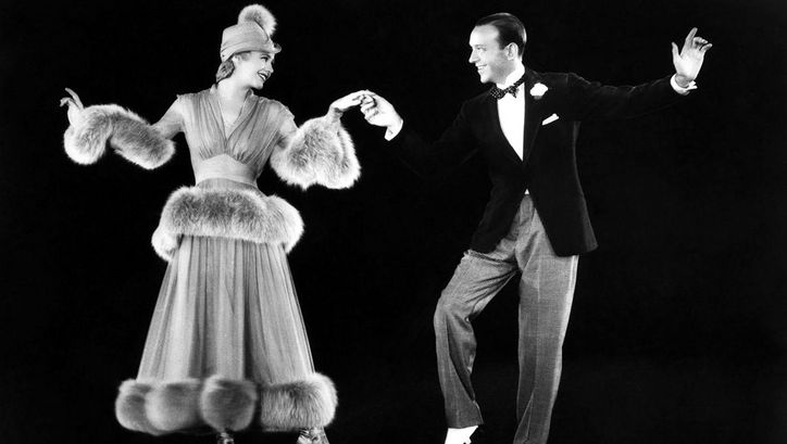 Filmstill aus THE STORY OF VERNON AND IRENE CASTLE. Ginger Rogers und Fred Astaire tanzen vor einem schwarzen Hintergrund.