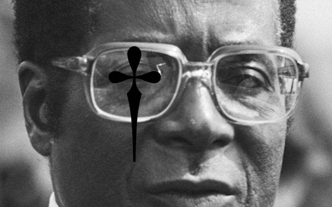 Film still from Heiko-Thandeka Ncube’s „The early rain which washes away the chaff before the spring rains“. A black and white portrait of a person with glasses. A black cross with rounded corners has been digitally laid over the right eye.