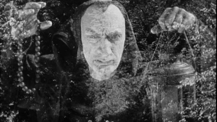 Filmstill aus ZVENYHORA: Ein Mann hält beschwörend beide Hände in die Höhe.