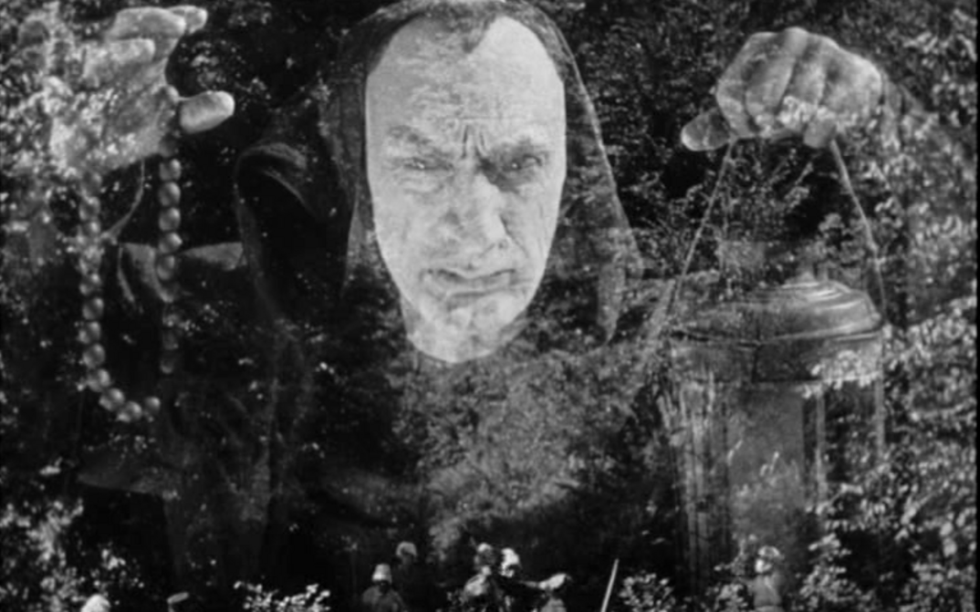 Filmstill aus ZVENYHORA: Ein Mann hält beschwörend beide Hände in die Höhe.