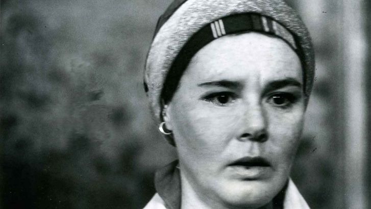 Film still from PILGRIM, FAREWELL: A woman looks into the camera.