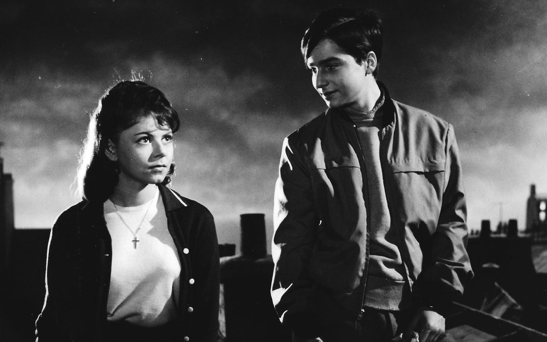 Film still from BOULEVARD: Two young people standing on a roof in Paris.