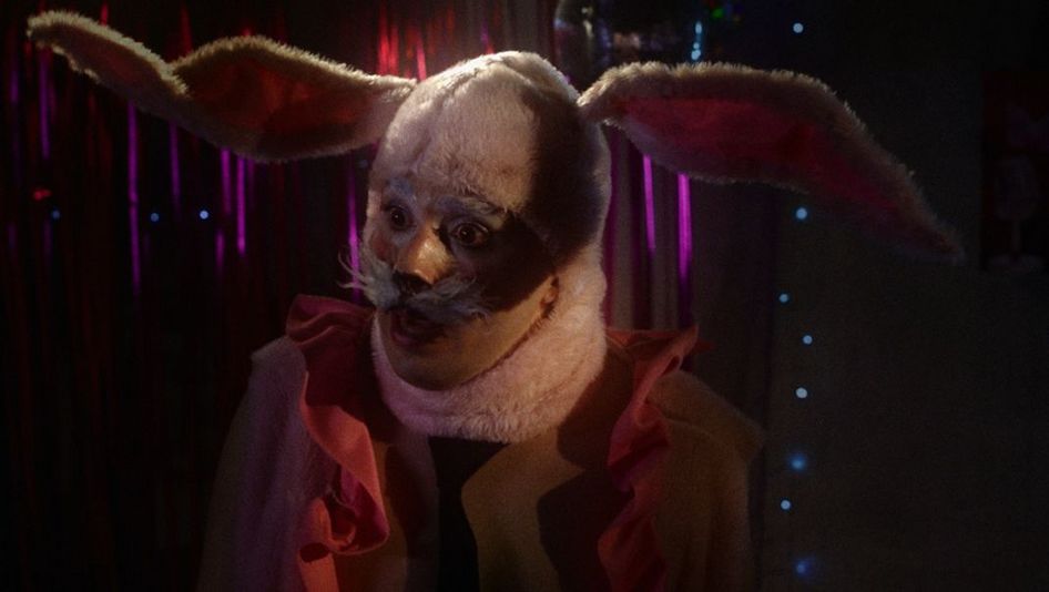 Film still from INFERNINHO: A person in a bunny costume.