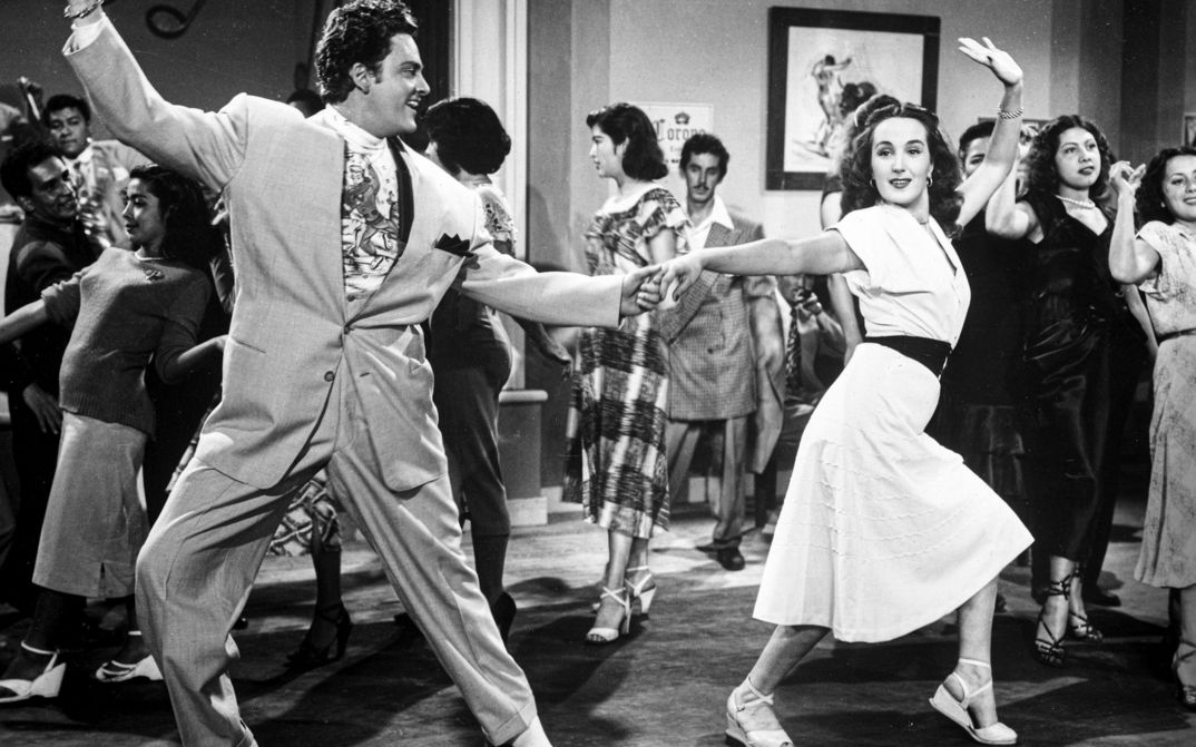 Filmstill aus EL SUAVECITO: Ein tanzendes Paar auf einer Party.