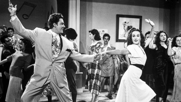 Film still from EL SUAVECITO: A dancing couple at a party.