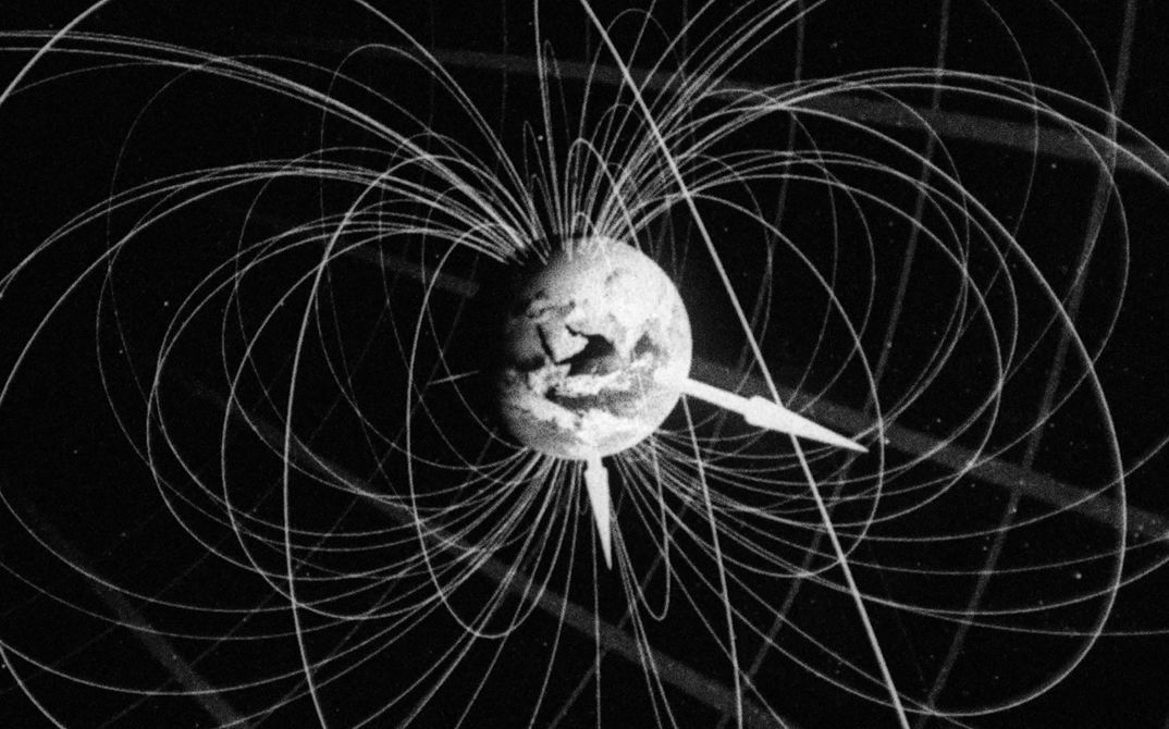 Film still from Deborah Stratman’s „Last Things“. A three-dimensional model of the earth in the centre of the picture, surrounded by its magnetic field lines and axiis.