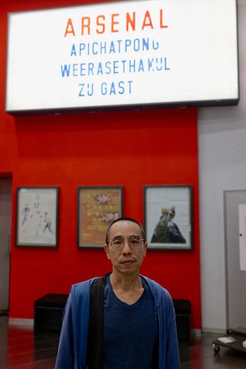 Porträt von Apichatpong Weerasethakul vor dem Leuchtkasten mit seinem Namen