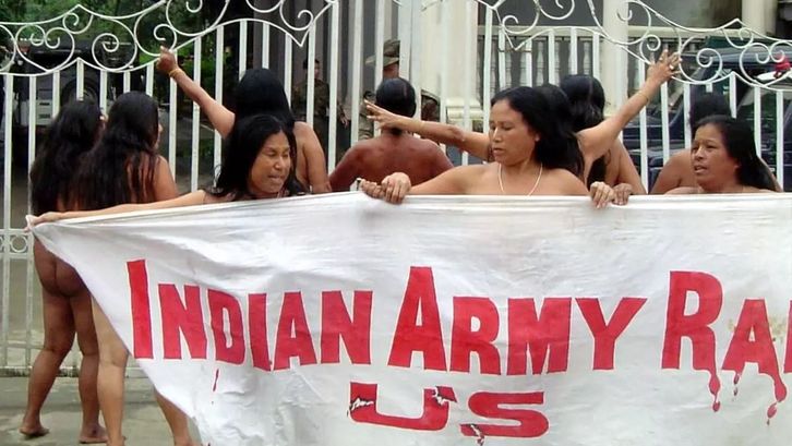 Film still from AFSPA, 1958: A group of unclothed women hold up a banner.