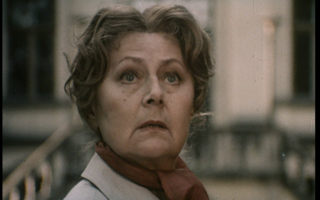 Filmstill aus DIE EINLADUNG: Eine ältere Frau blickt nach oben.