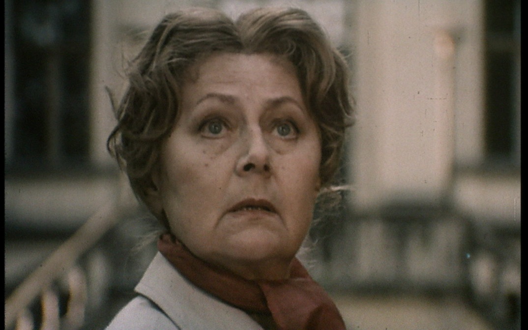 Filmstill aus DIE EINLADUNG: Eine ältere Frau blickt nach oben.