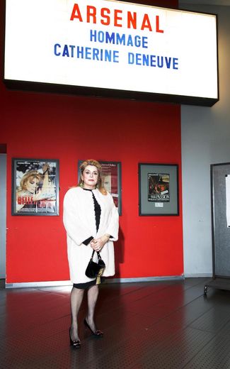 Catherine Deneuve vor Leuchtkasten mit ihrem Namen 