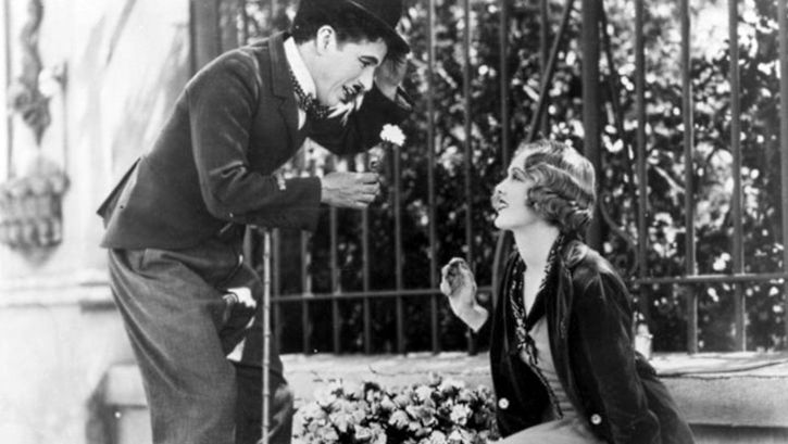 Film still from CITY LIGHTS: Charlie Chaplin and a flower girl.