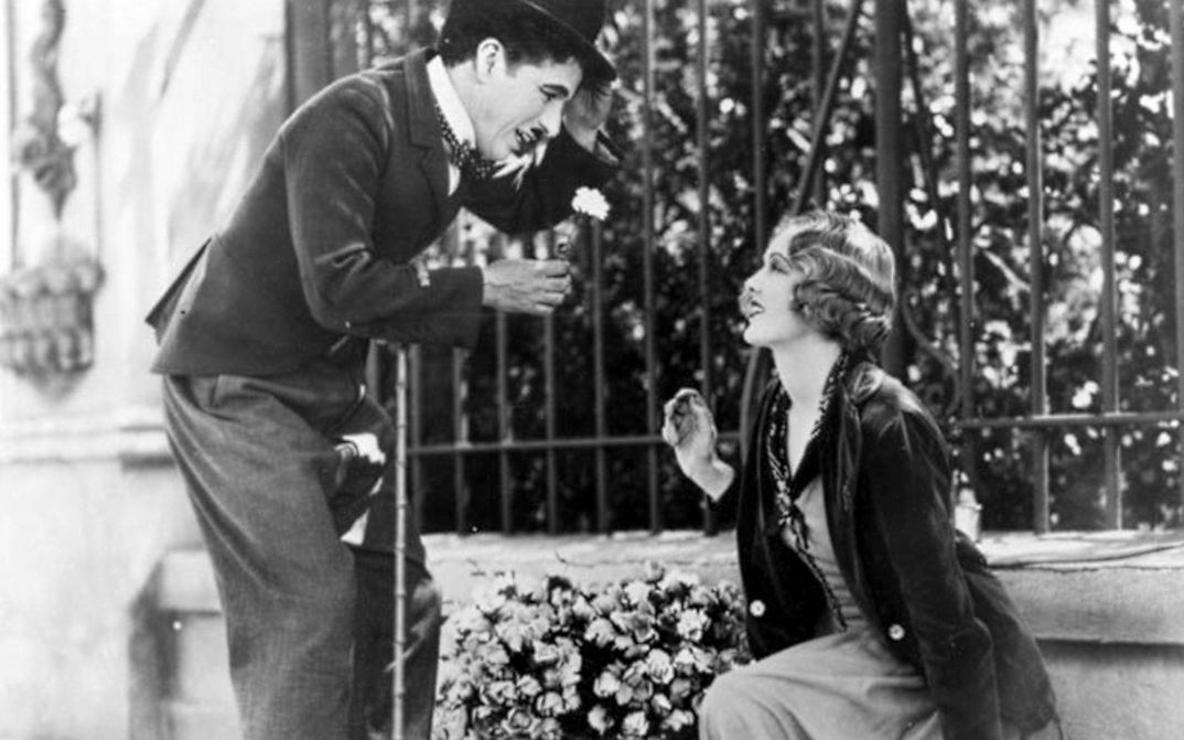 Filmstill aus CITY LIGHTS: Charlie Chaplin und eine junge Blumenverkäuferin.