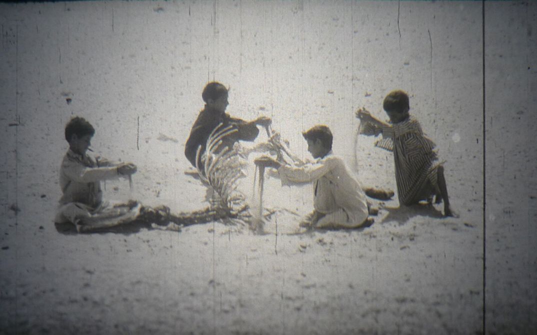 Filmstill aus "Alltagsleben in einem syrischen Dorf": Eine Gruppe von Kindern spielt mit Sand.