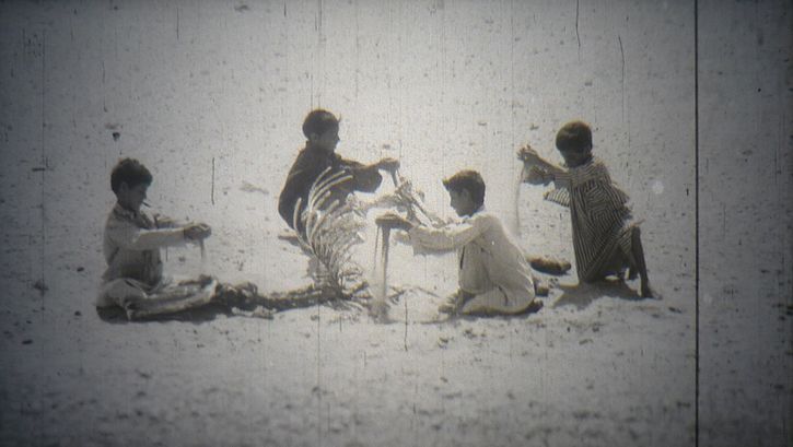 Filmstill aus "Alltagsleben in einem syrischen Dorf": Eine Gruppe von Kindern spielt mit Sand.