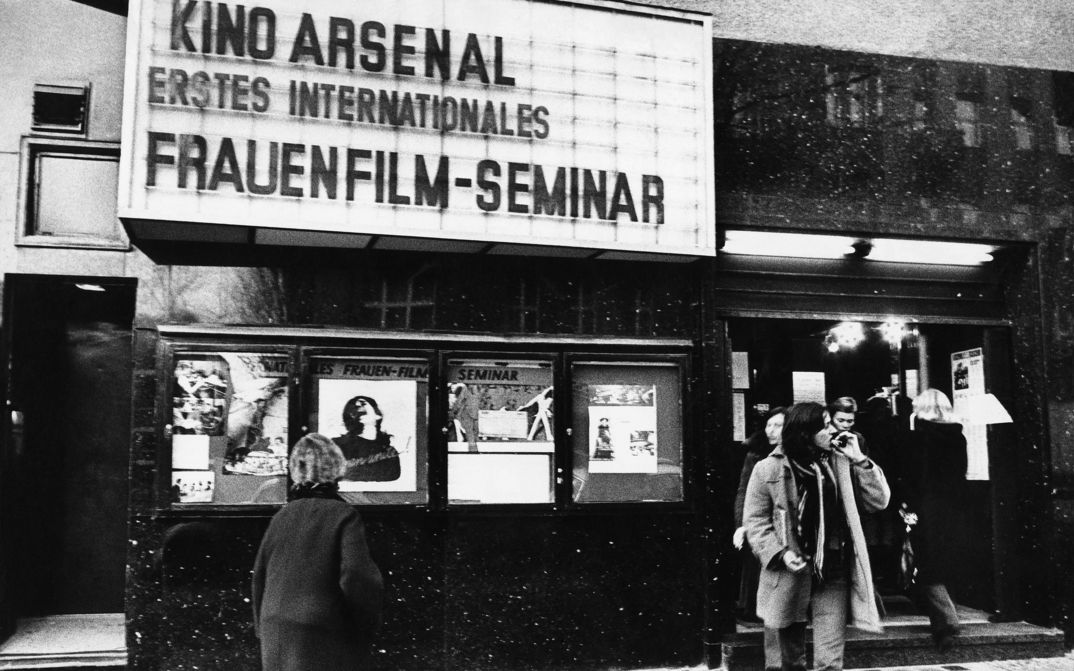 Filmstill aus ERSTES INTERNATIONALES FRAUENFILM-SEMINAR: Außenansicht des Kinos Arsenal mit Leuchtanzeige und Schaukästen.