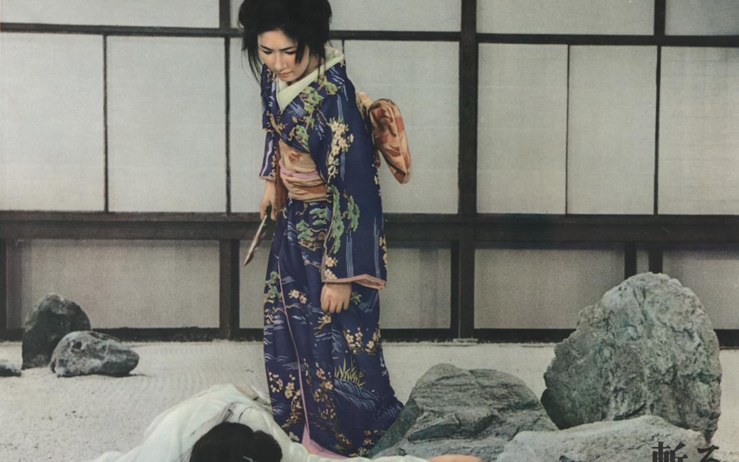 Film still from KIRU: A woman in a kimono holds a knife in her hand and stands over a person lying on the ground.