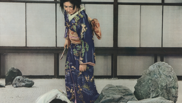 Film still from KIRU: A woman in a kimono holds a knife in her hand and stands over a person lying on the ground.