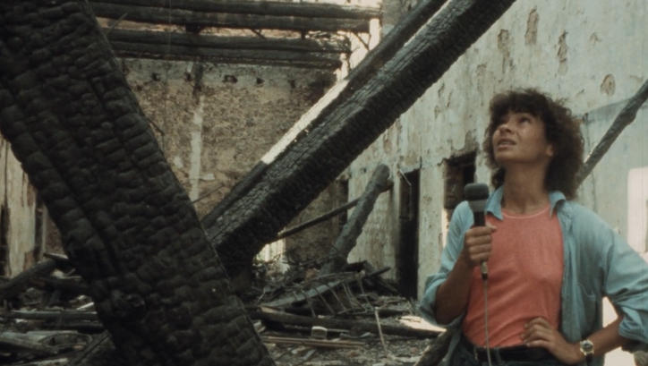 Film still from BEIRUT MY CITY: A young woman with a microphone in her hand stands in a destroyed house.