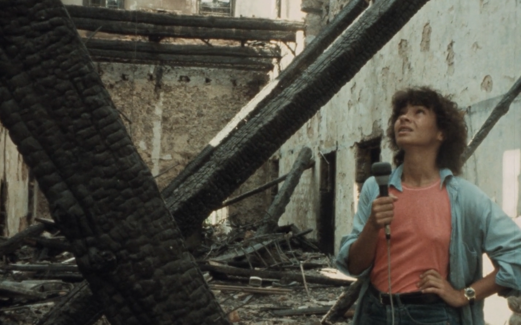 Filmstill aus BEIRUT MY CITY: Eine junge Frau mit Mikrofon in der Hand steht in einem zerstörten Haus.