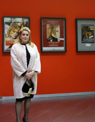 Catherine Deneuve vor Filmpostern 