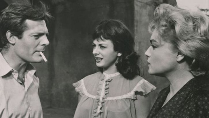 Film still from ADUA E LE COMPAGNE: Marcello Mastroianni stands next to Sandra Milo and Simone Signoret.