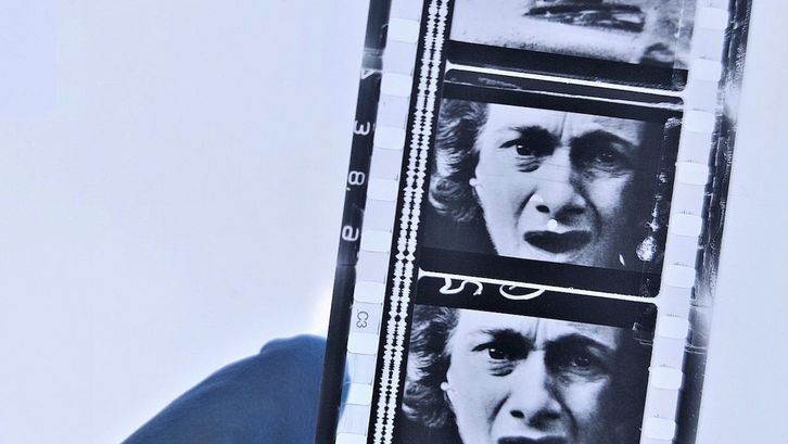 A hand is holding a film strip.