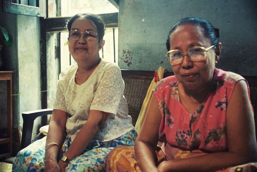 Die Erzählerinnen Daw Khin Myint Kyi (links) und Daw Ah Mar Sein (rechts) sitzen auf einer Coach