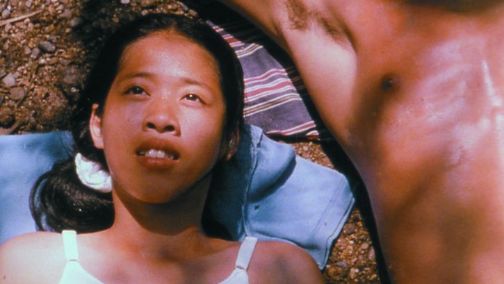 Film still from BLISSFULLY YOURS: A young woman is lying in the sun, next to her is the naked torso of a man.