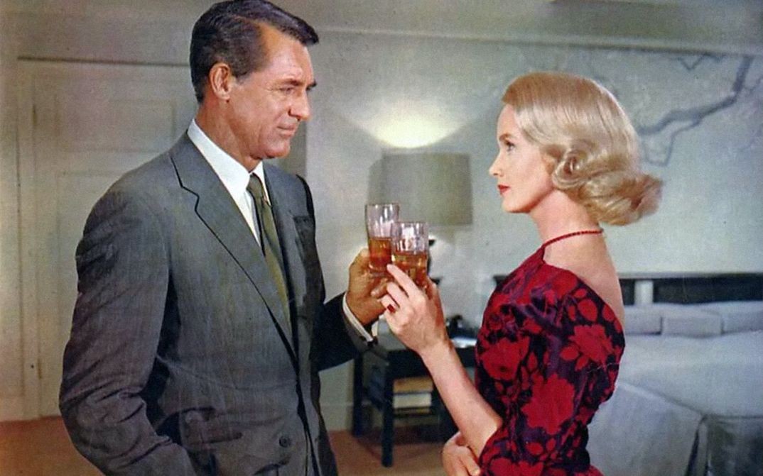 Film still from NORTH BY NORTHWEST: A man and a woman, both elegantly dressed, toast each other.