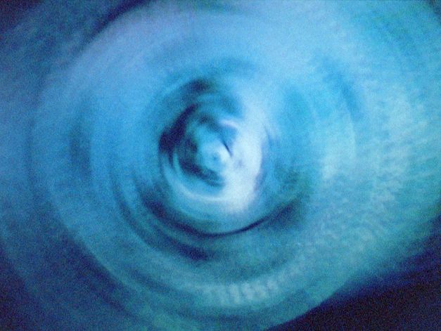 Filmstill aus dem Film "vs" von Lydia Nsiah. Abstrakte Spirale in blauer Farbe.