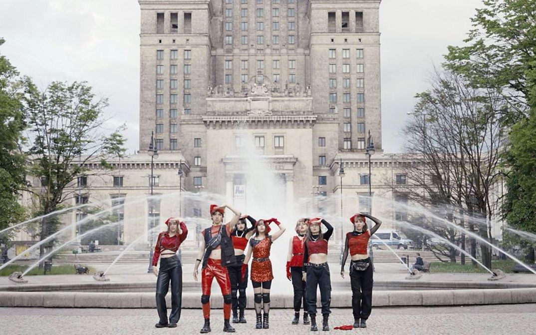 Still from the film "If Revolution Is a Sickness" by Diane Severin Nguyen. Seven people salute in front of a fountain.