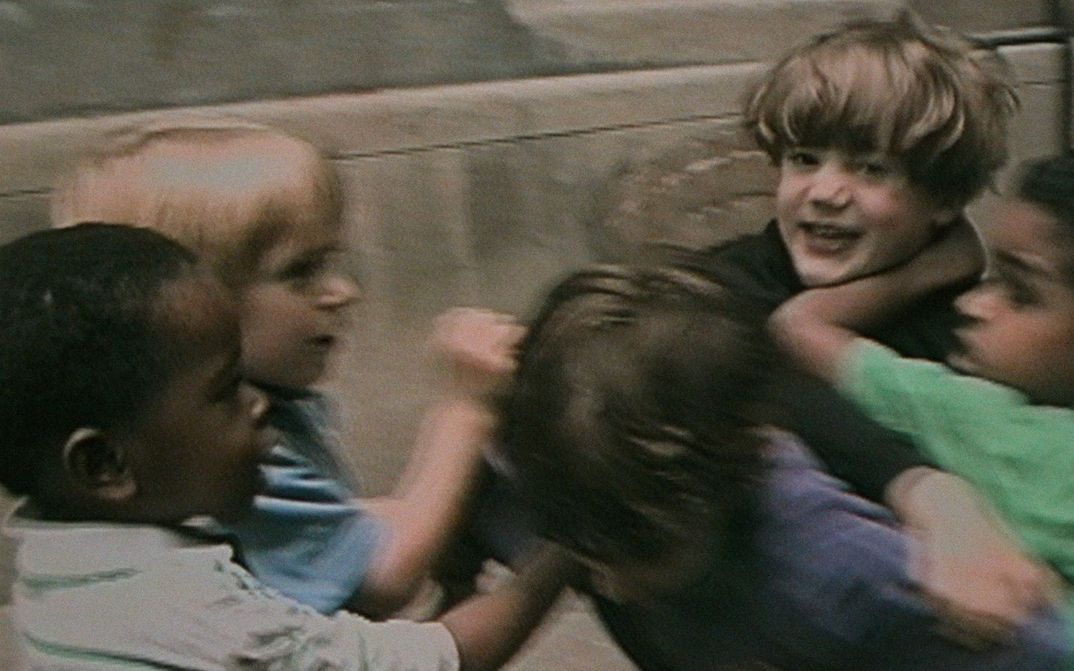 Filmstill aus RÉCRÉATIONS: Eine Gruppe von Kindern beim spielerischen Kampf.