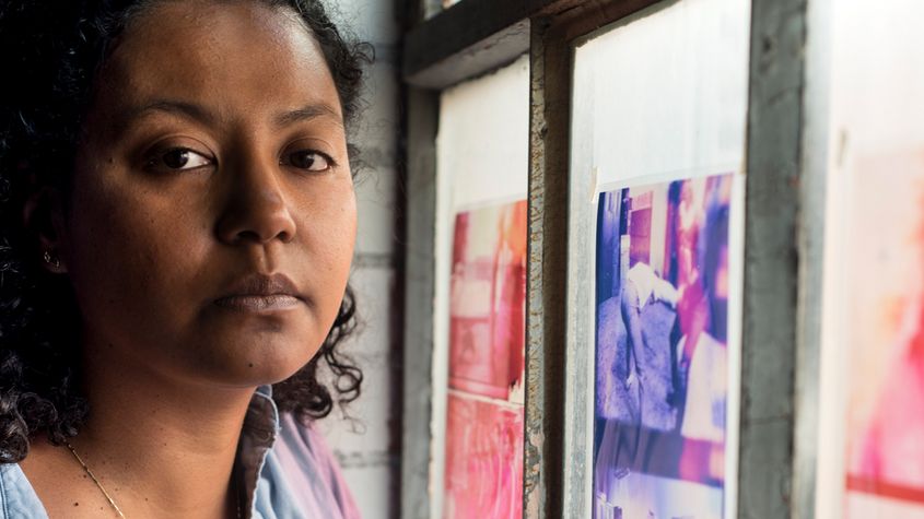 Portrait of Crystal Z Campbell standing next to a colorful window.