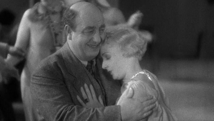 Film still from DAVID GOLDER: A woman in a ball gown leans on a man