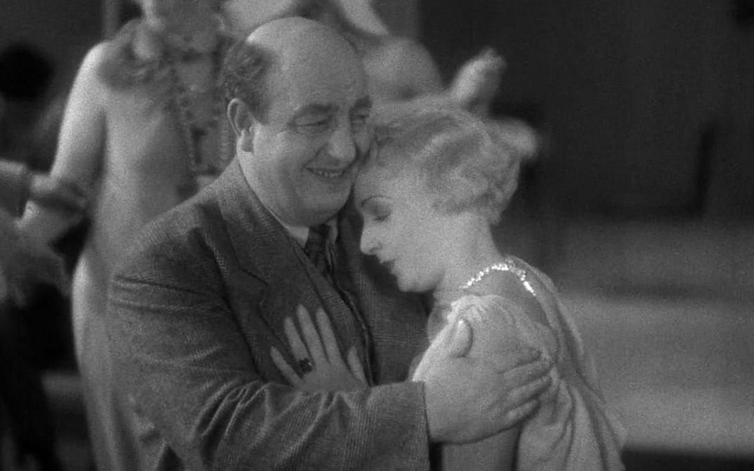 Film still from DAVID GOLDER: A woman in a ball gown leans on a man